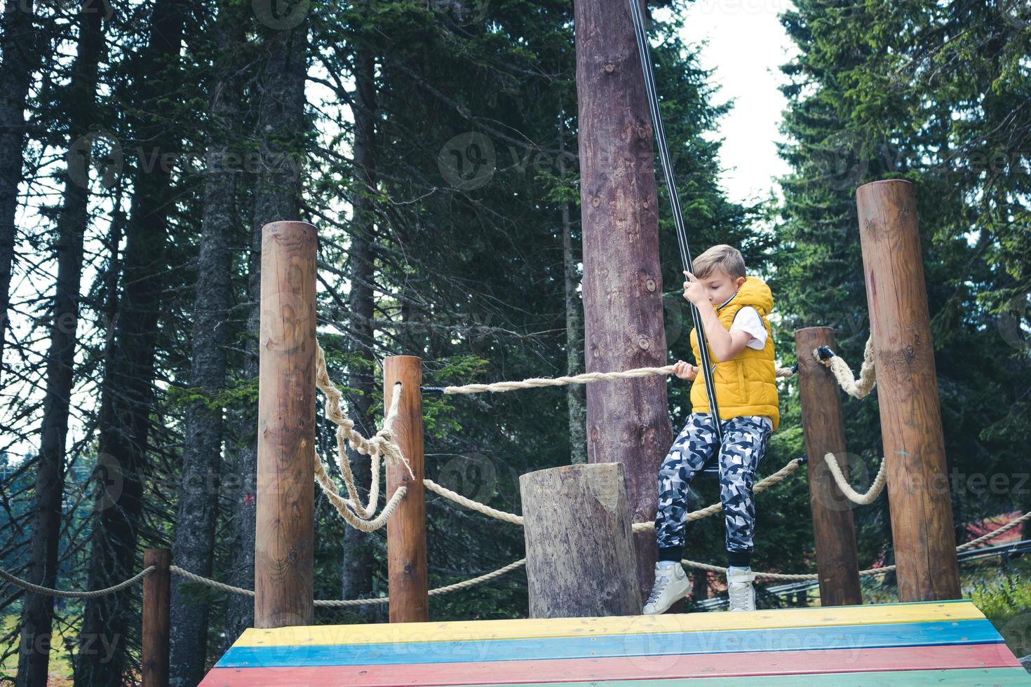 Small boy getting ready for rappelling from zip line. photo