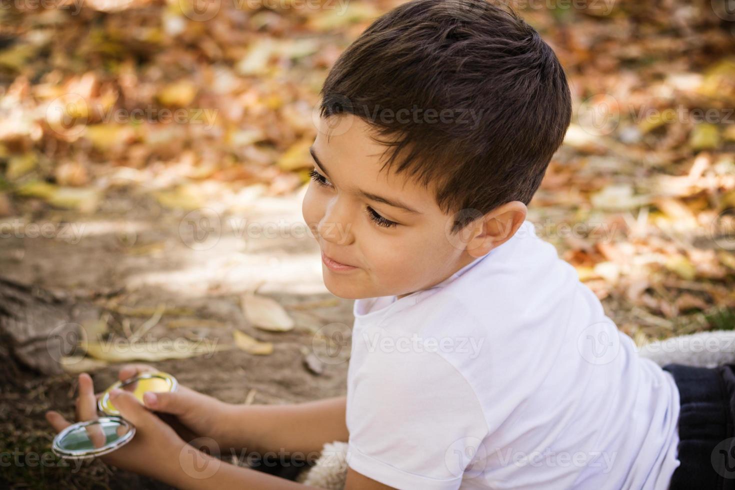 lindo niño sonriente disfrutando en el día de otoño en la naturaleza. foto