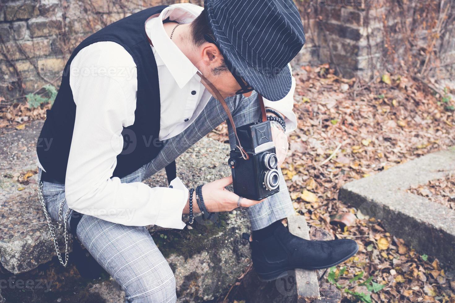 Photographer looking through visor and taking photo with medium format camera.