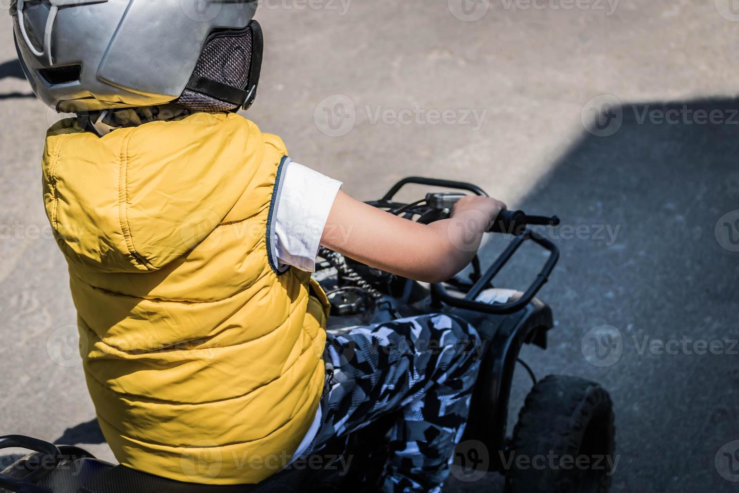 Back view of a kid driving on the road. photo