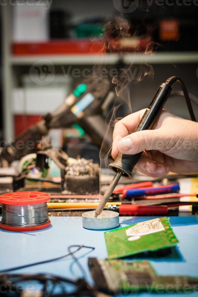 Close up of man soldering computer component. photo