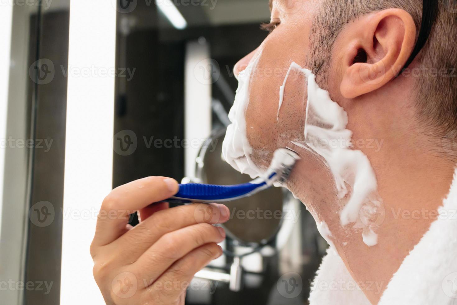 primer plano de hombre afeitándose en el baño. foto