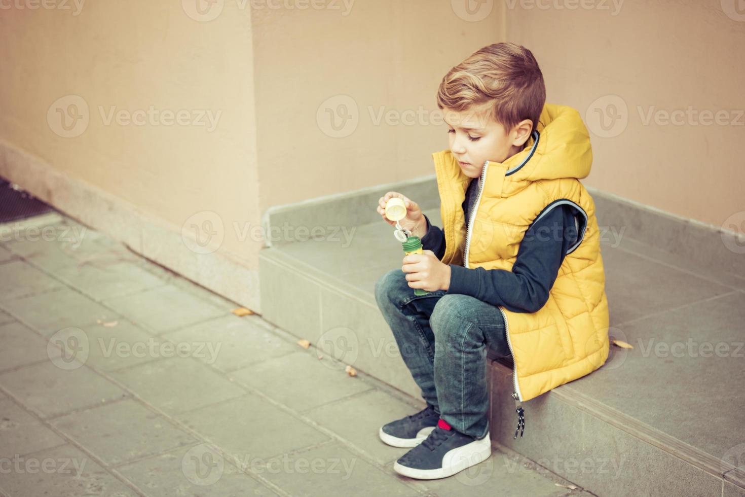 Small boy with bubble wand relaxing outdoors. photo