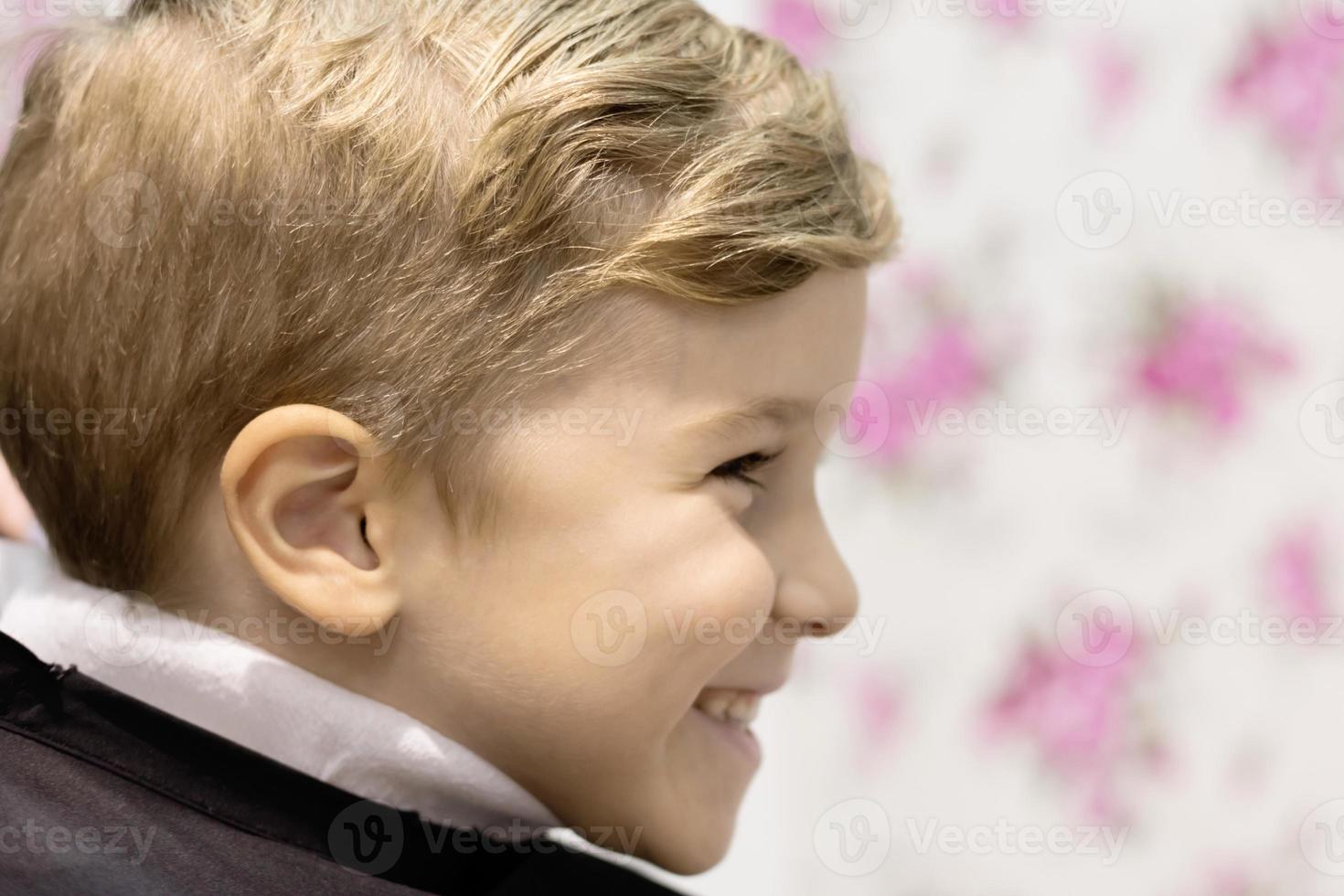 Profile view of happy boy at hairdresser. photo