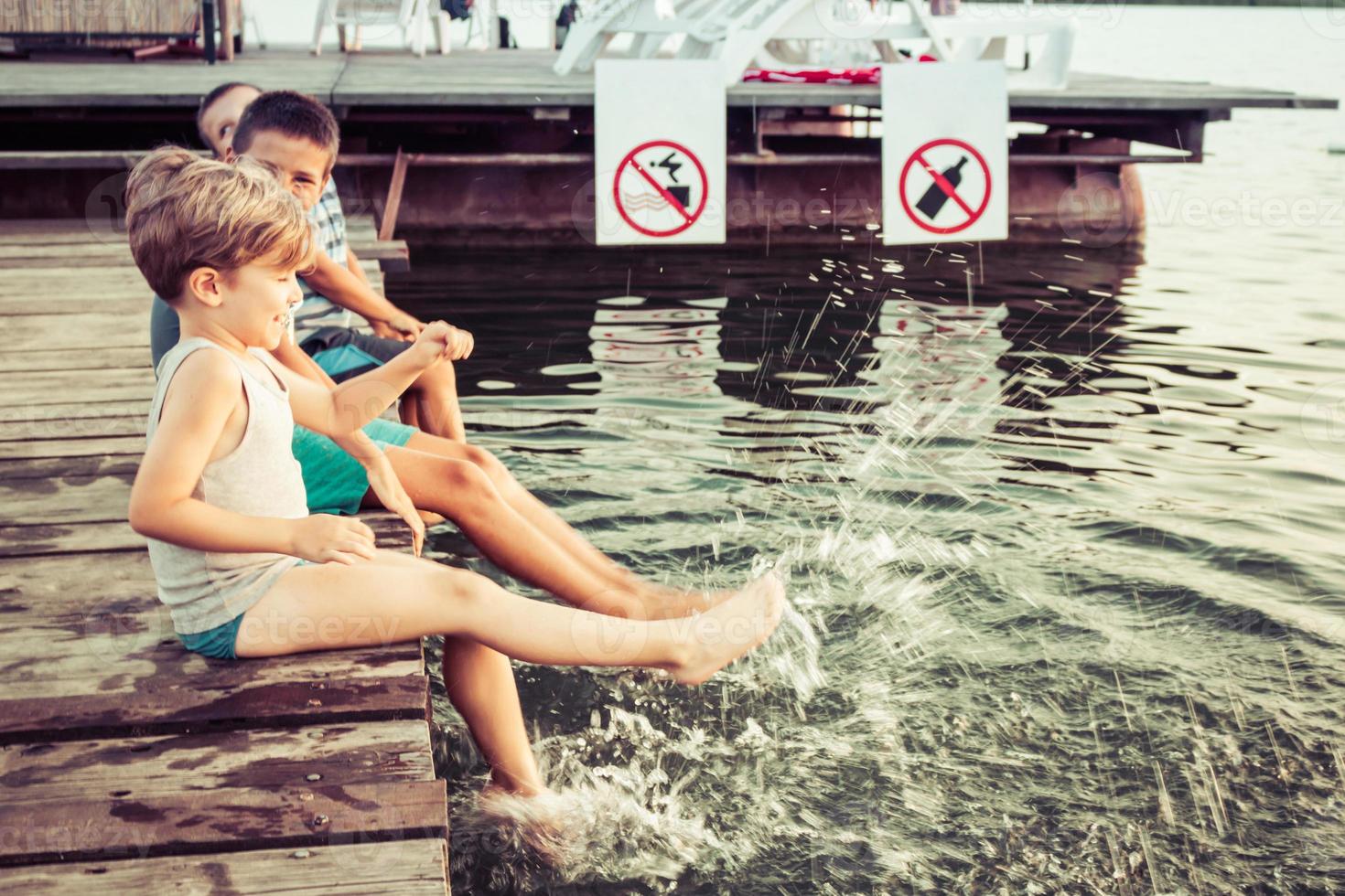 Playful kids having fun while relaxing on a pier. photo