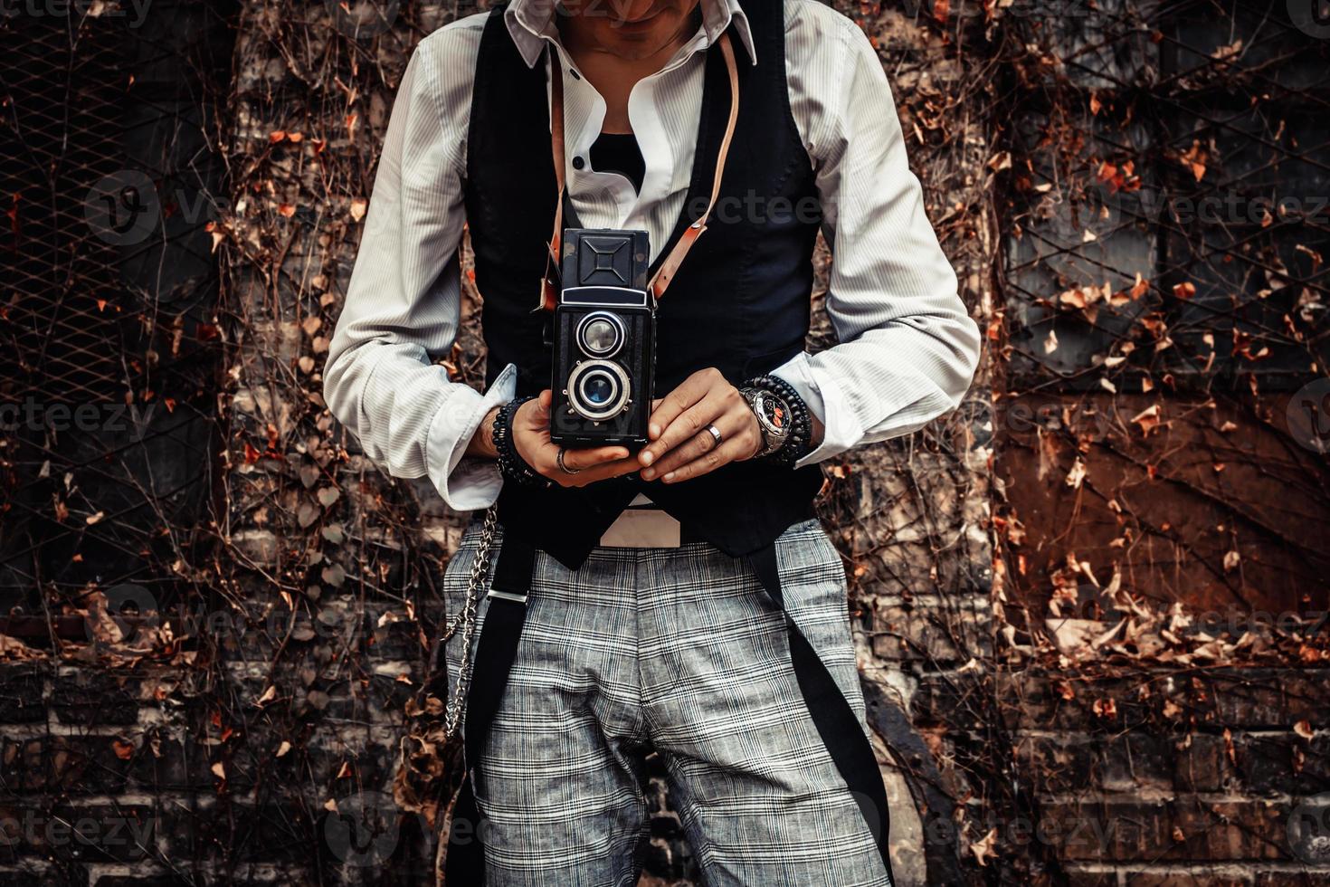 Unrecognizable photographer taking picture with vintage medium format photo camera.