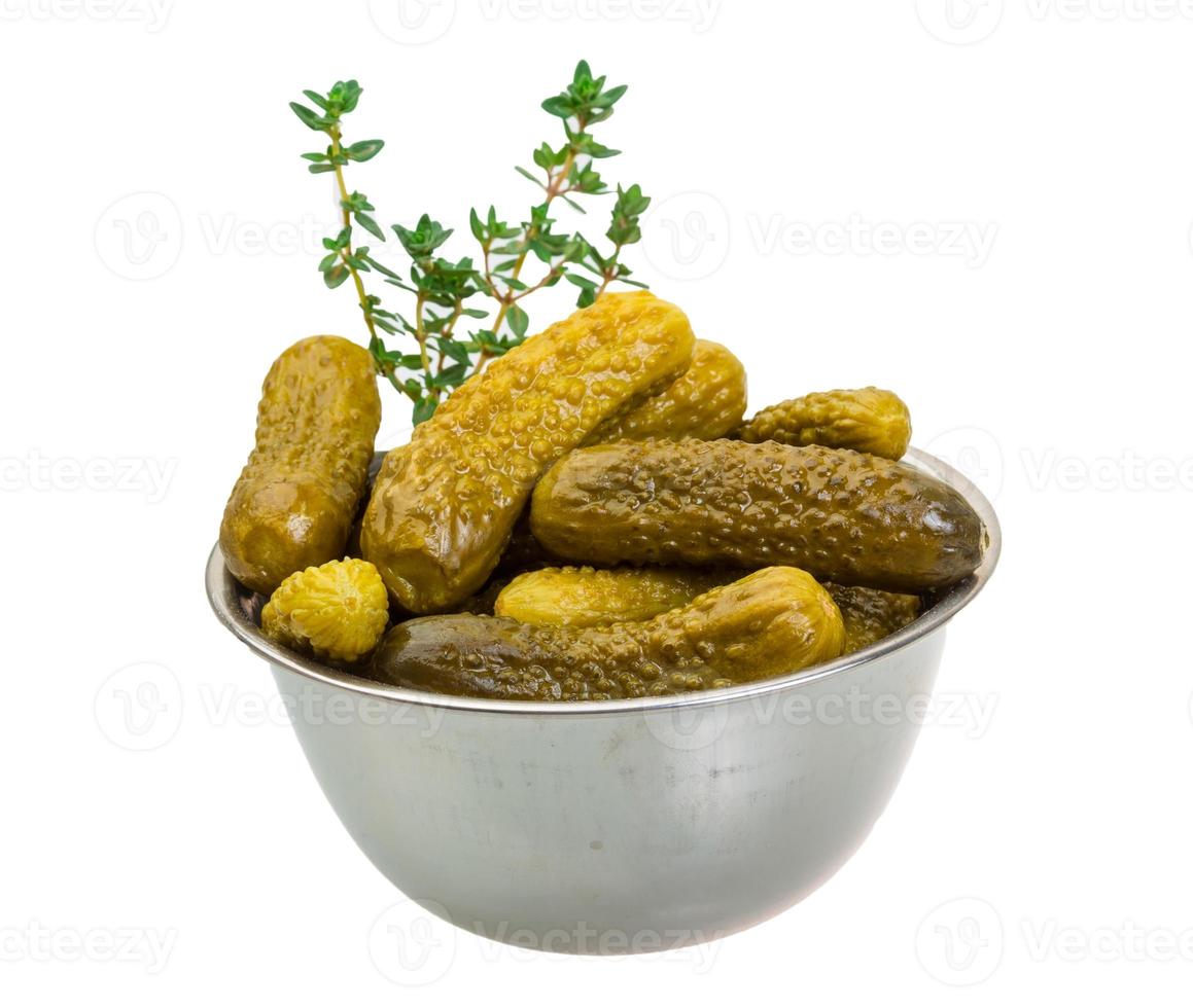 Marinated cucumbers in a bowl on white background photo