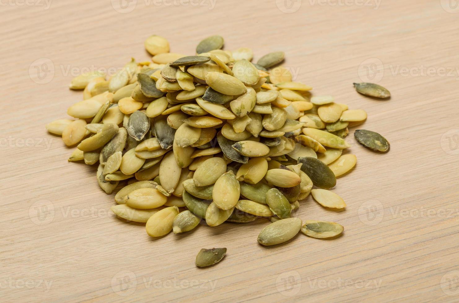 Pumpkin seeds on wooden background photo