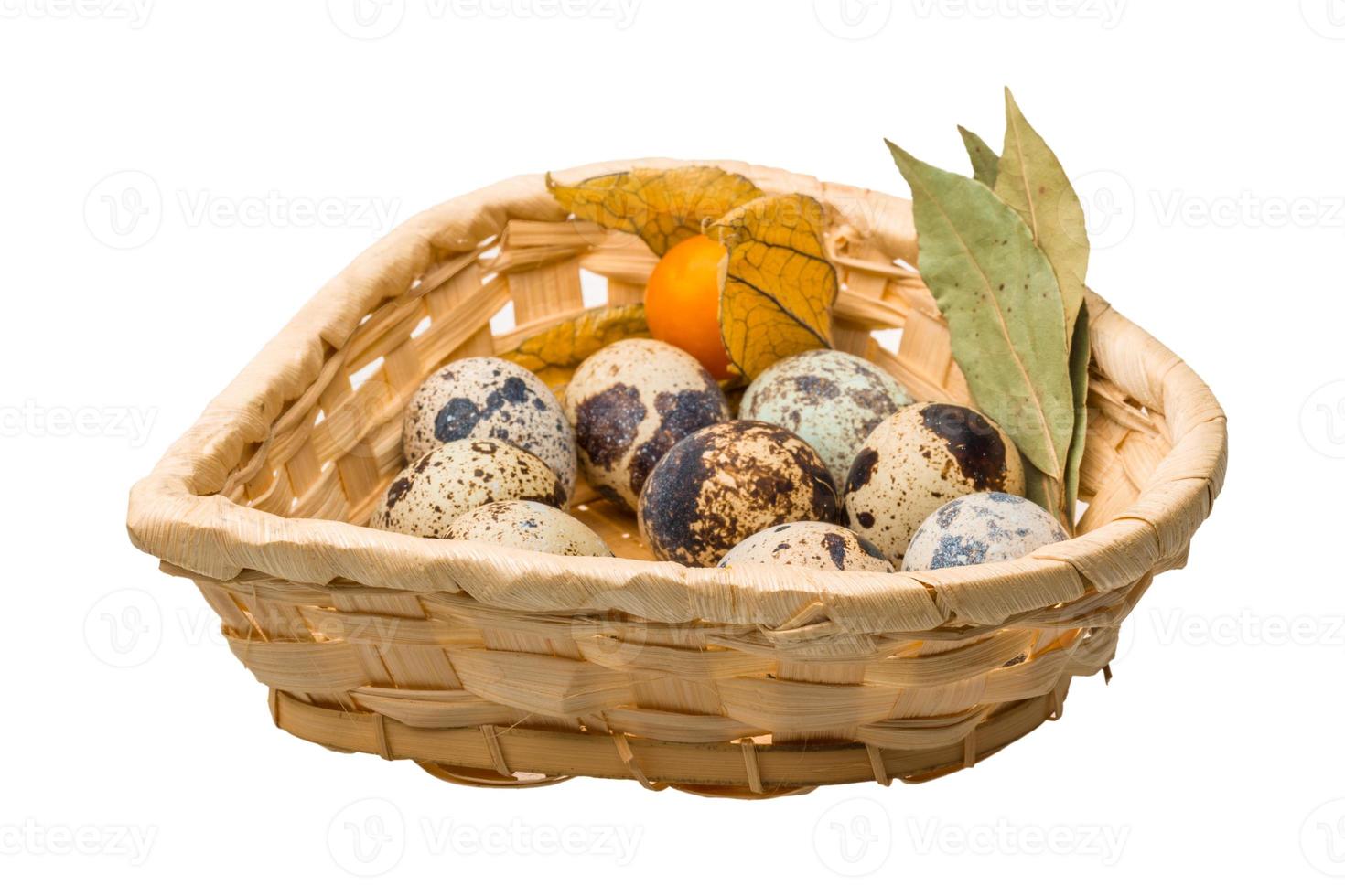 huevos de codorniz en una canasta sobre fondo blanco foto