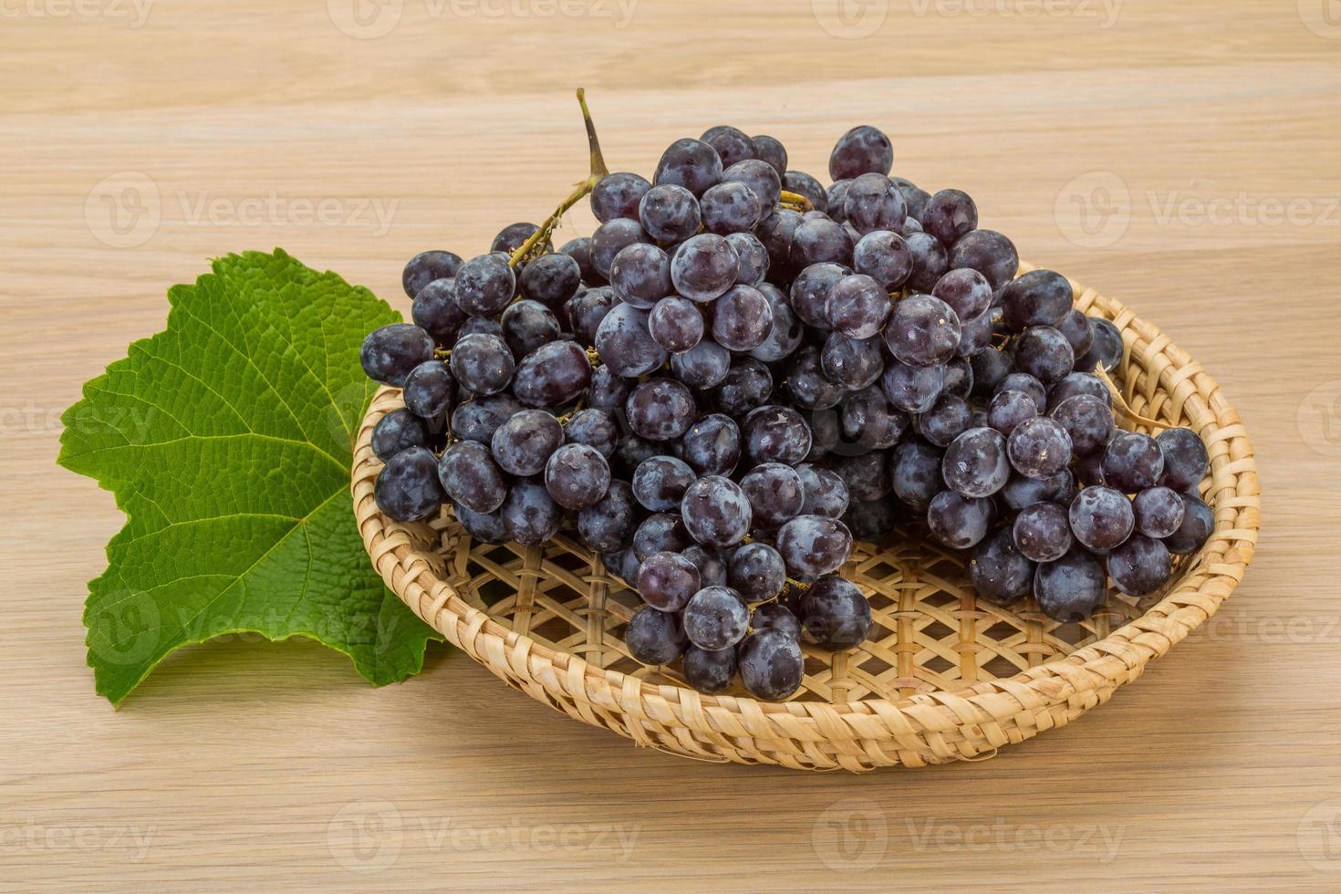 Grape in a basket on wooden background photo