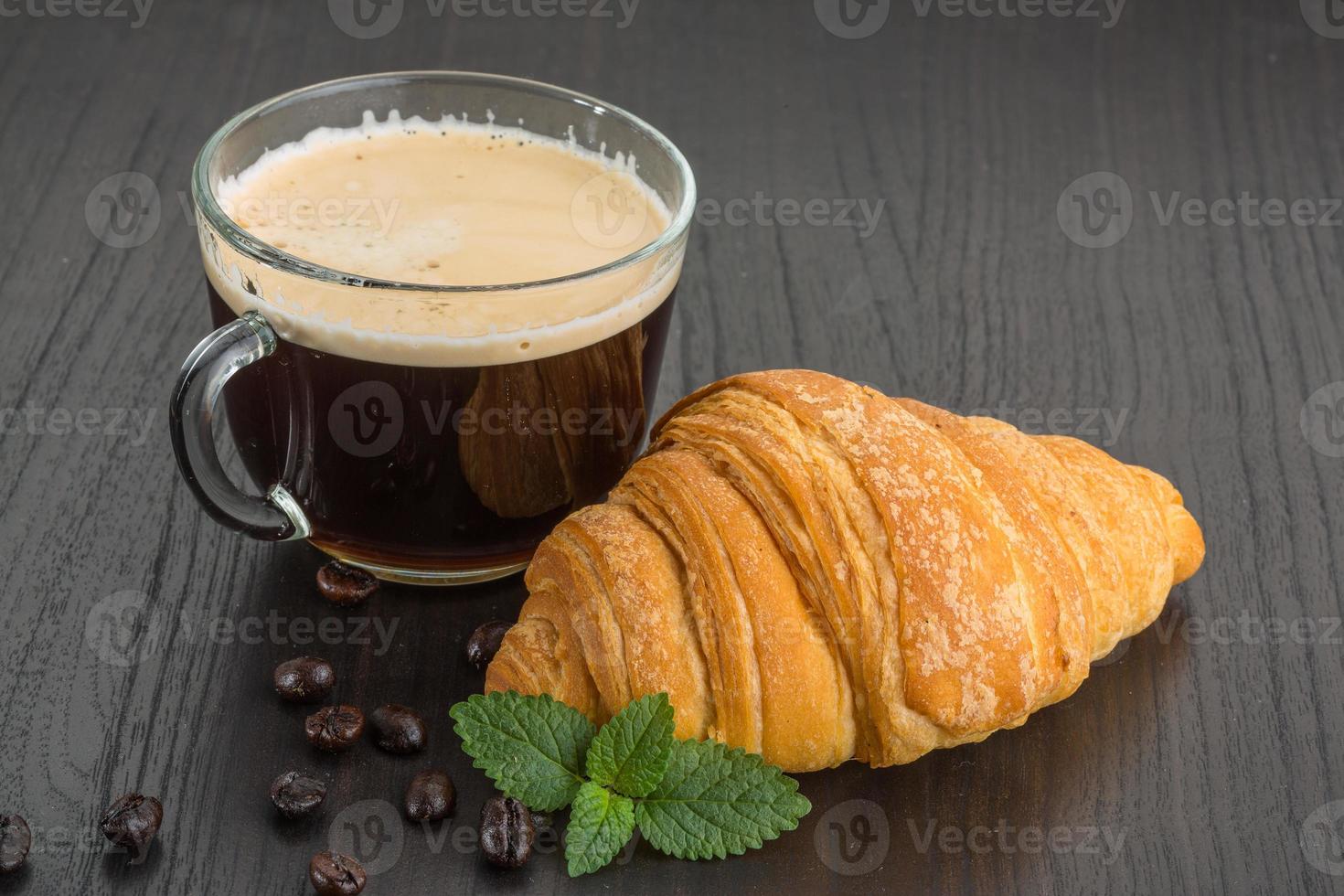 Coffee with croissant on wooden background photo