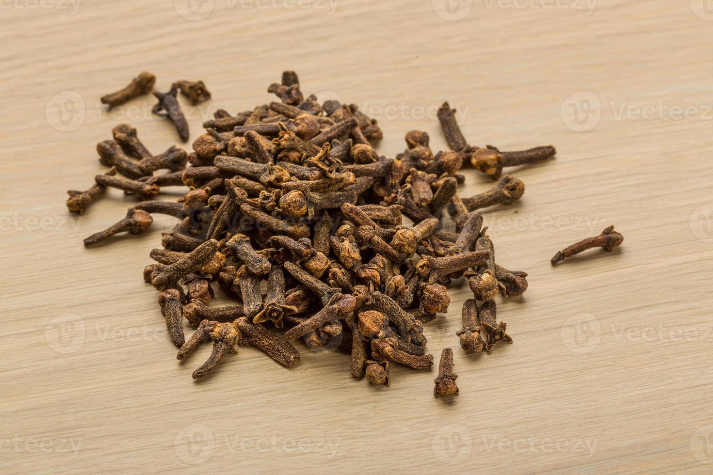 Clove seeds on wooden background photo