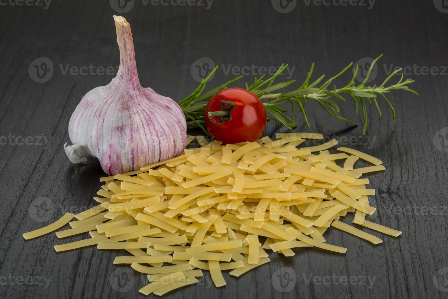 Raw macaroni on wooden background photo