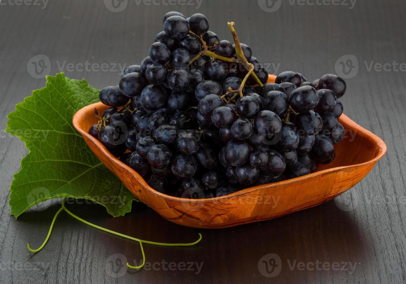 Grape in a bowl on wooden background photo