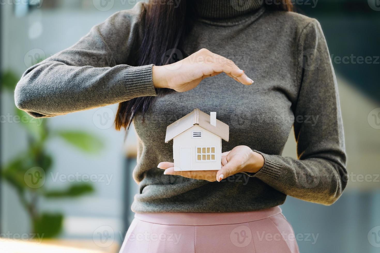 Real estate agent gesturing to protect homes, housing insurance concept. photo