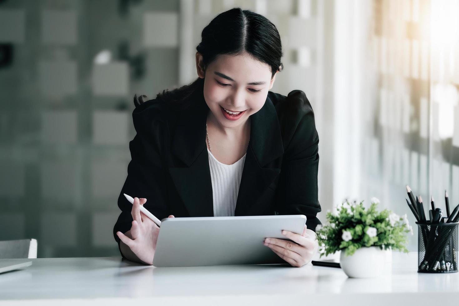 Female marketing managers use tablet computer calls via Facetime with venture capital firms to increase profit potential. photo