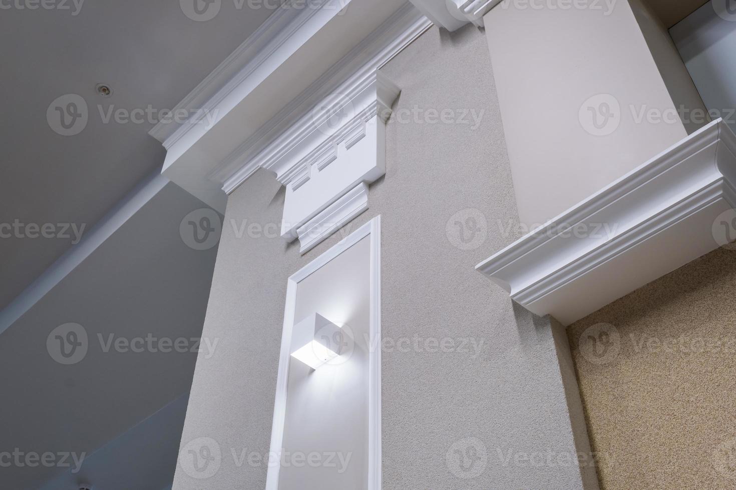 Detail of corner ceiling with intricate crown molding on column with spot light photo