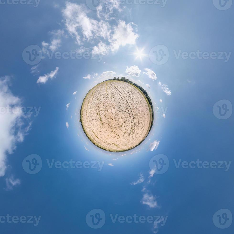 tiny planet transformation of spherical panorama 360 degrees. Spherical abstract aerial view in field with clear sky and awesome beautiful clouds. Curvature of space. photo