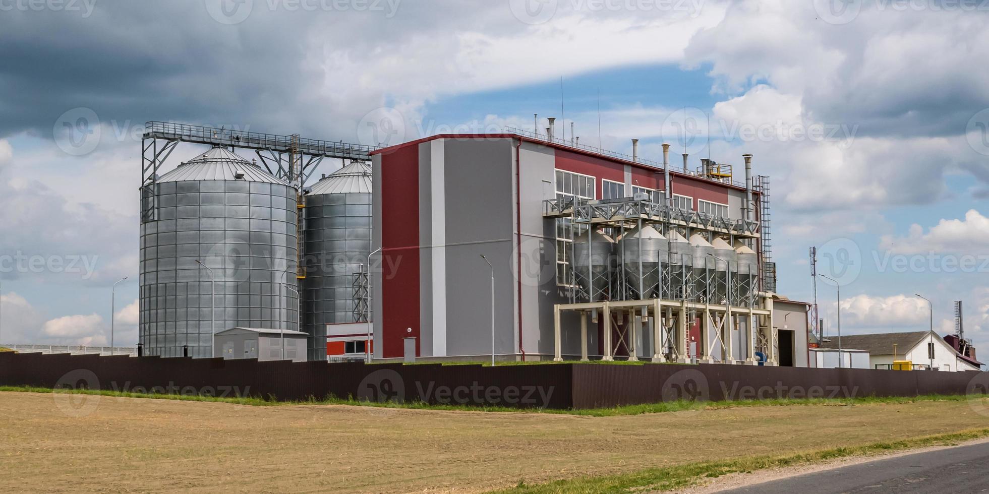 Modern Granary elevator and seed cleaning line. Silver silos on agro-processing and manufacturing plant for processing drying cleaning and storage of agricultural products, flour, cereals and grain. photo