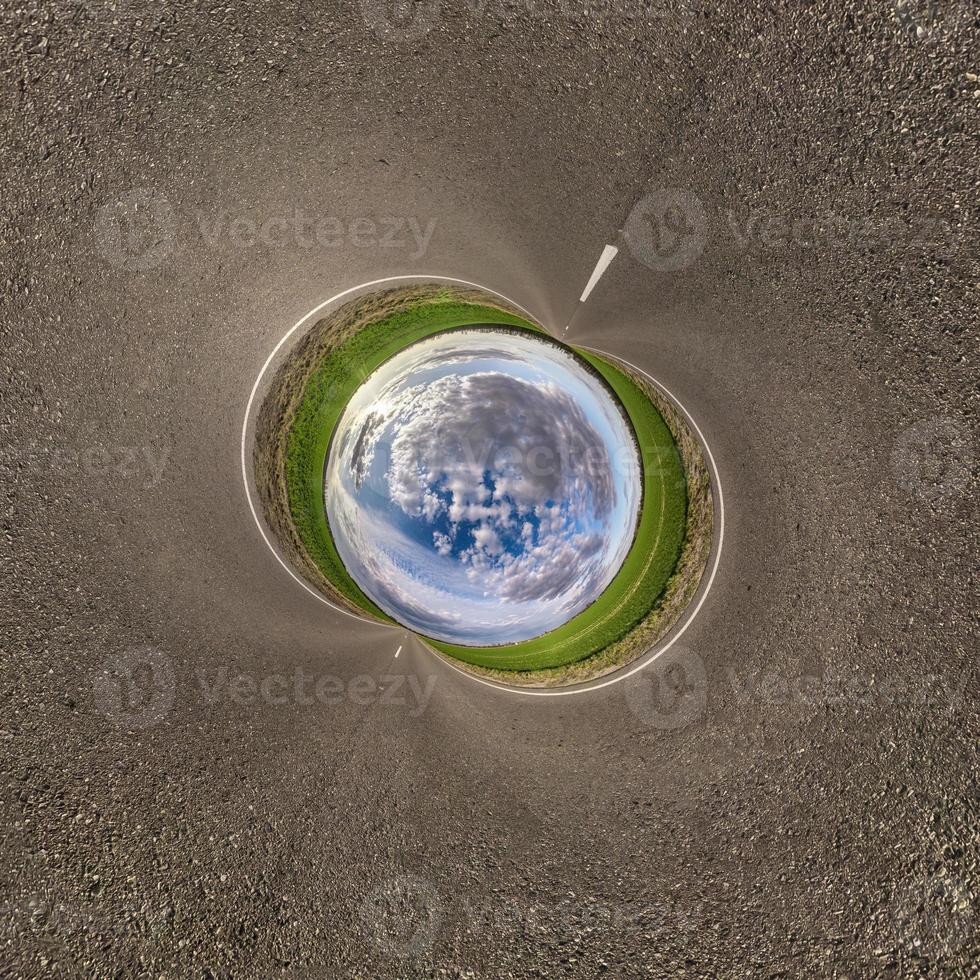 Inversion of blue little planet transformation of spherical panorama 360 degrees. Spherical abstract aerial view on road with awesome beautiful clouds. Curvature of space. photo