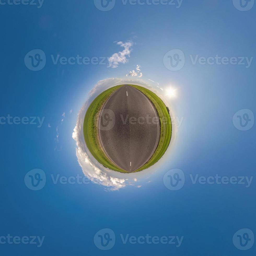 green tiny planet in blue sky with beautiful clouds. Transformation of spherical panorama 360 degrees. Spherical abstract aerial view. Curvature of space. photo