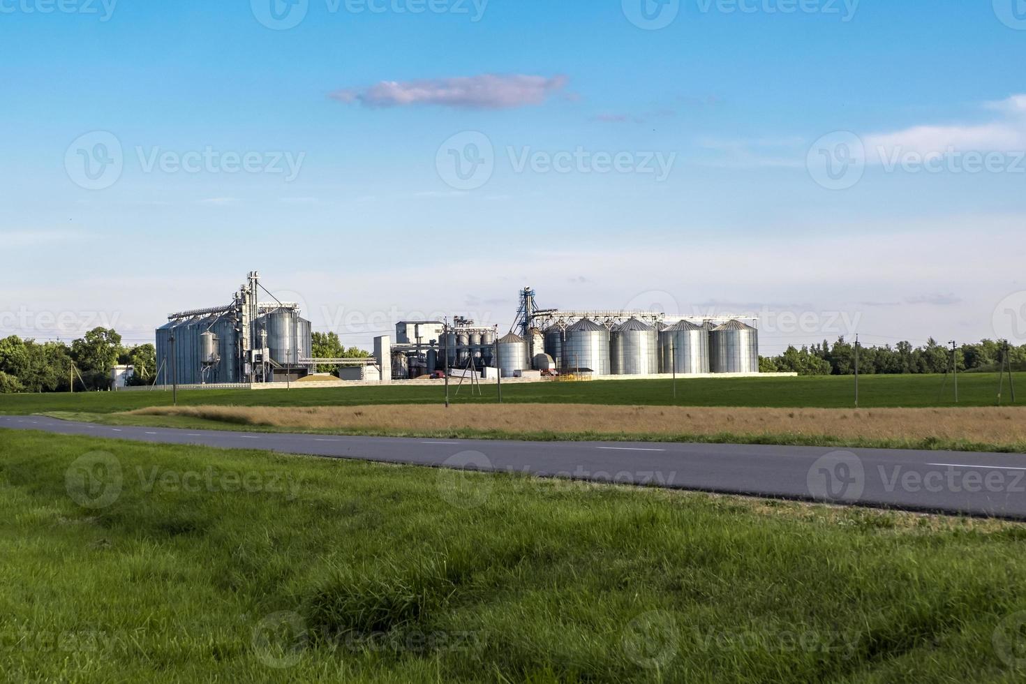 Modern Granary elevator. Silver silos on agro-processing and manufacturing plant for processing drying cleaning and storage of agricultural products, flour, cereals and grain. photo
