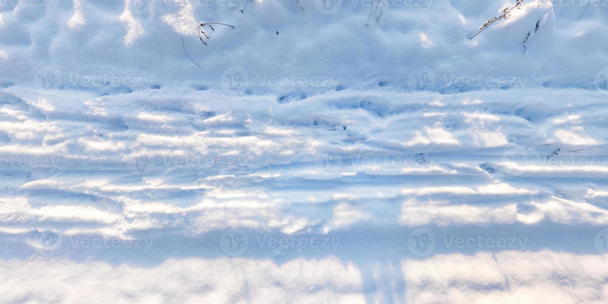 panorama view from above on texture of snow covered road with car tire tracks and footprints photo