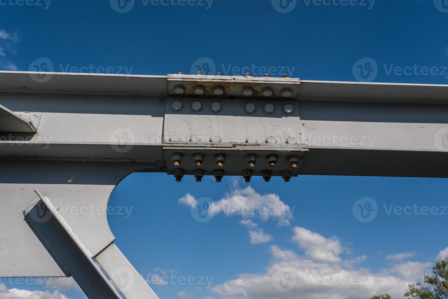 iron steel frame construction of bridge on blue sky background. bridge metal structures, frames, bolts and nuts photo
