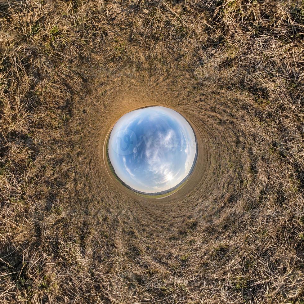 Inversion of little planet transformation of spherical panorama 360 degrees. Spherical abstract aerial view on field with awesome beautiful clouds. Curvature of space. photo