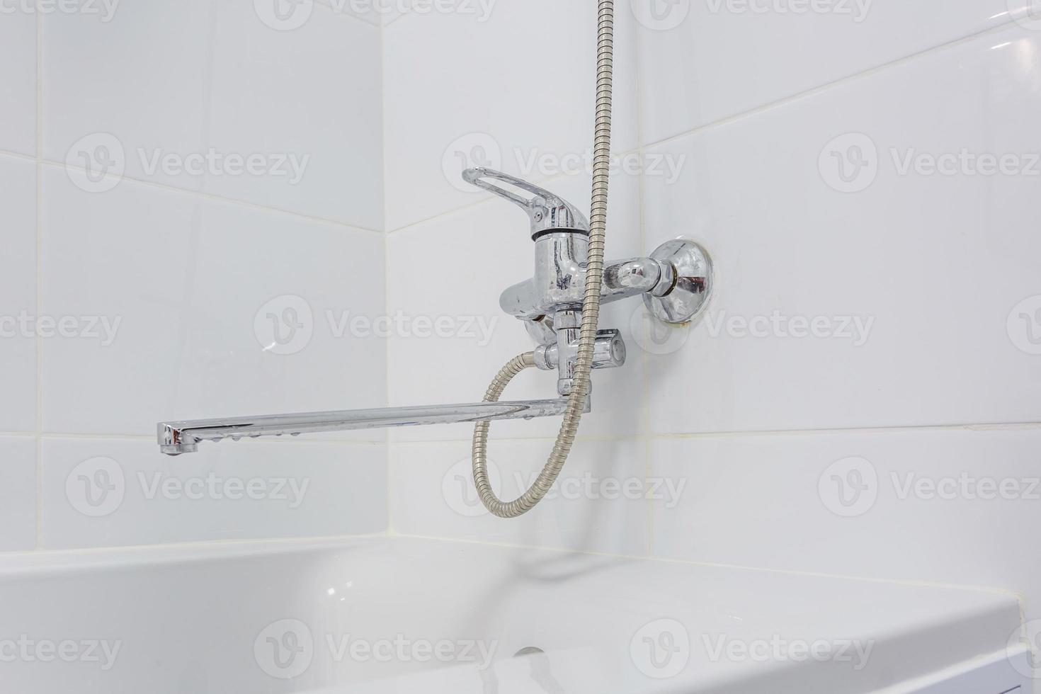 fregadero con grifo de agua en baño caro con accesorio de ducha de montaje en pared foto