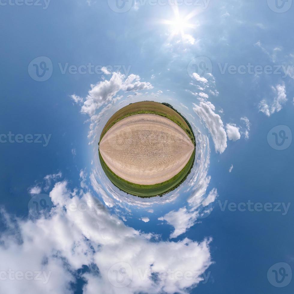 tiny planet in blue sky with sun and beautiful clouds. Transformation of spherical panorama 360 degrees. Spherical abstract aerial view. Curvature of space. photo