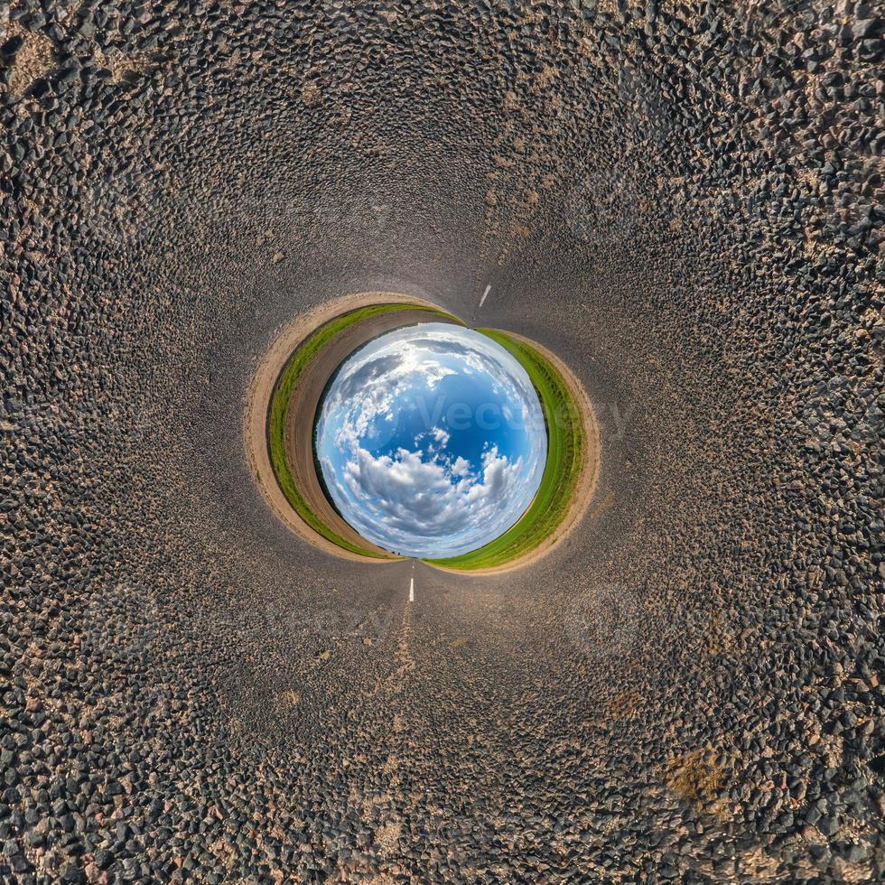 bola de cielo azul en medio de una carretera o campo de asfalto giratorio. inversión de la transformación del pequeño planeta del panorama esférico de 360 grados. vista abstracta esférica. curvatura del espacio. foto