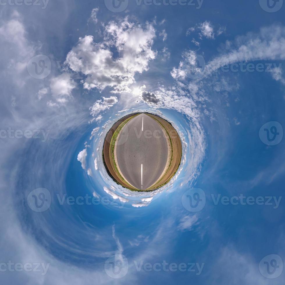 tiny planet in blue sky with beautiful clouds. Transformation of spherical panorama 360 degrees. Spherical abstract aerial view. Curvature of space. photo