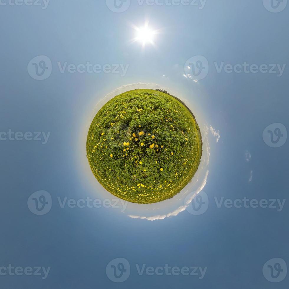 green tiny planet in blue sky with beautiful clouds. Transformation of spherical panorama 360 degrees. Spherical abstract aerial view. Curvature of space. photo