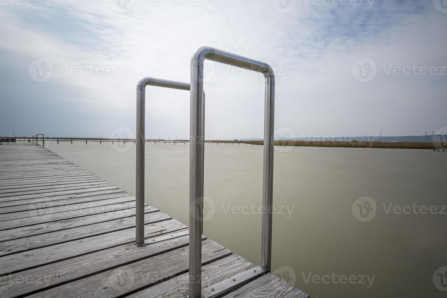 A Wooden Pier with Aluminum Pool Deck Ladder with Hand Rail on Neusiedlersee in Austria. photo