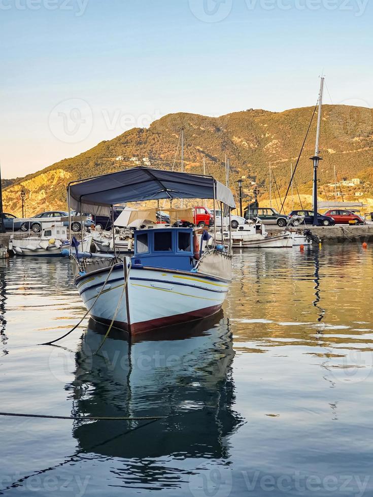 An anchored boat in the sea at the marina with nice reflection in water at Skopelos, Greece. photo