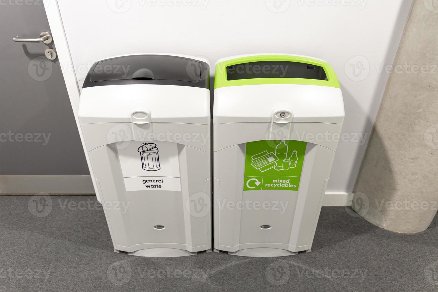 Different colored bins for collection of recycle materials. photo