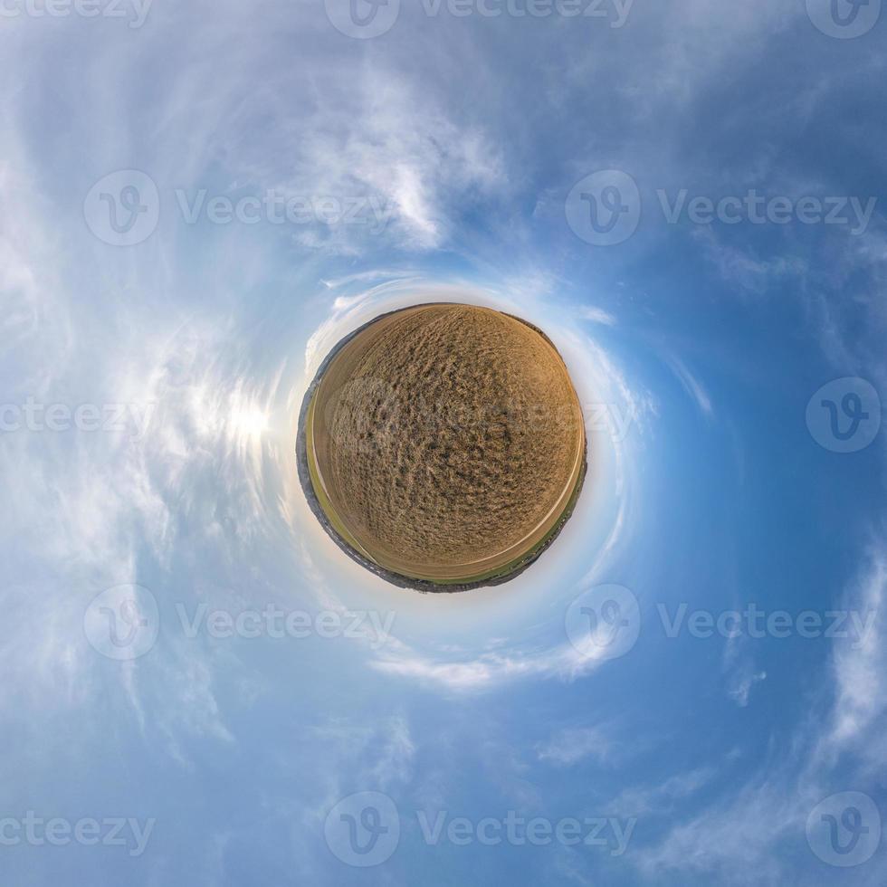 Little planet transformation of spherical panorama 360 degrees. Spherical abstract aerial view in field with clear sky and awesome beautiful clouds. Curvature of space. photo