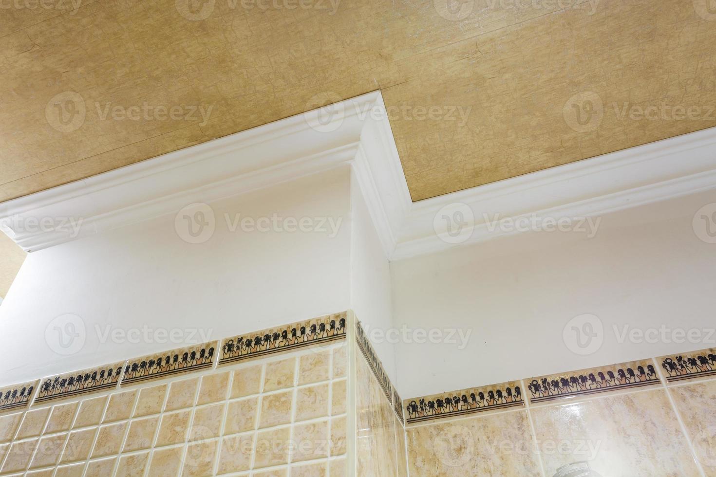Detail of corner ceiling with intricate crown molding. Suspended ceiling and drywall construction in empty room in apartment or house. Stretch ceiling white and complex shape. photo