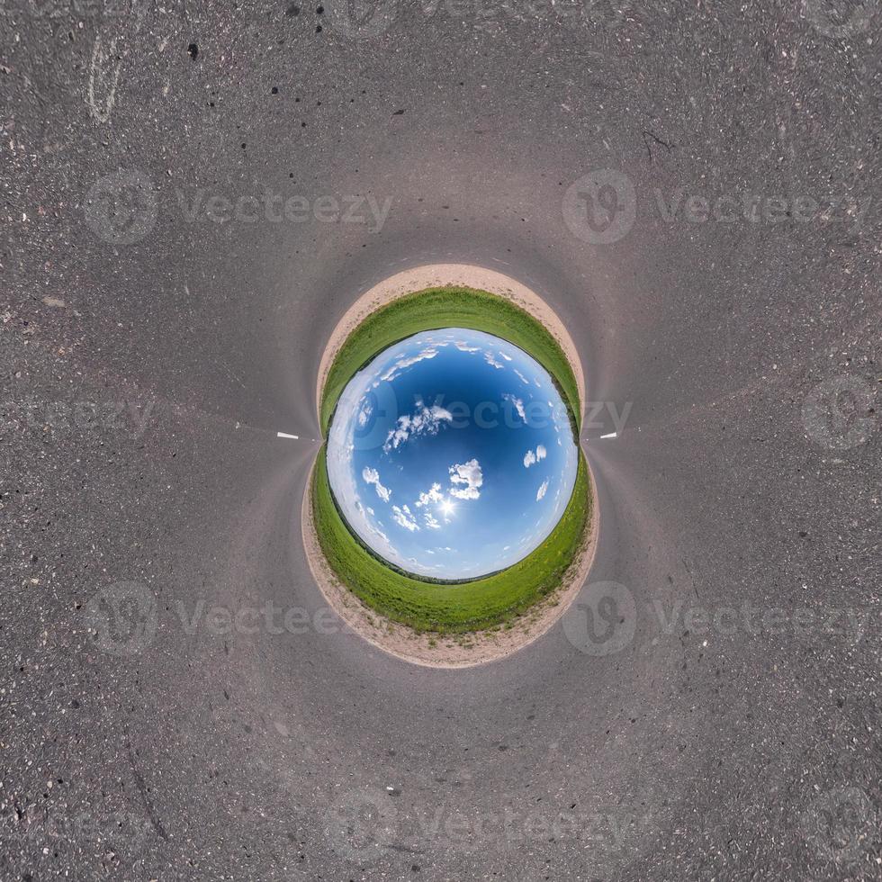 Inversion of blue little planet transformation of spherical panorama 360 degrees. Spherical abstract aerial view on road with awesome beautiful clouds. Curvature of space. photo
