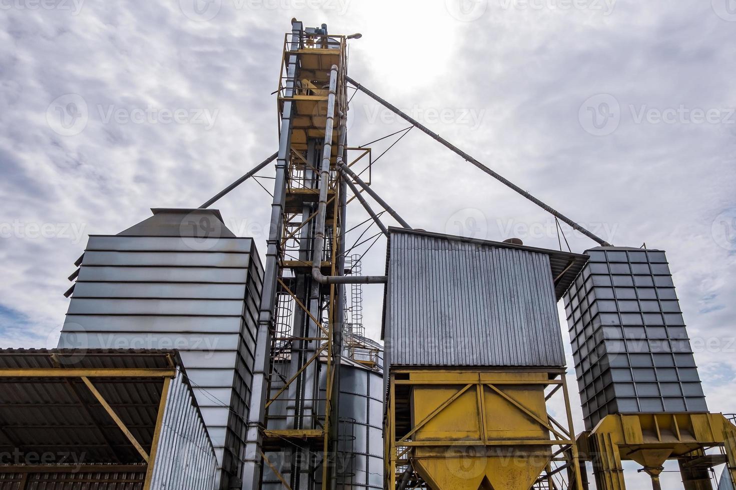 Modern Granary elevator. Silver silos on agro-processing and manufacturing plant for processing drying cleaning and storage of agricultural products, flour, cereals and grain. photo