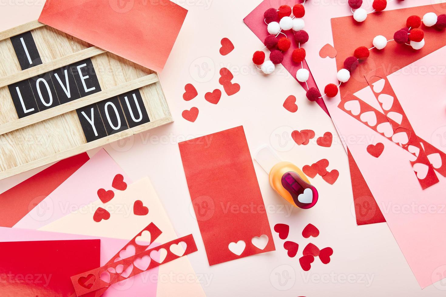 fondo del día de san valentín. corazones de papel, papel de colores, cortador de papel y texto de ingenio de letterboard foto