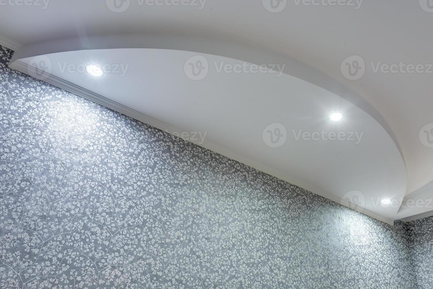 Detail of corner ceiling with intricate crown molding. Suspended ceiling and drywall construction in empty room in apartment or house. Stretch ceiling white and complex shape. photo