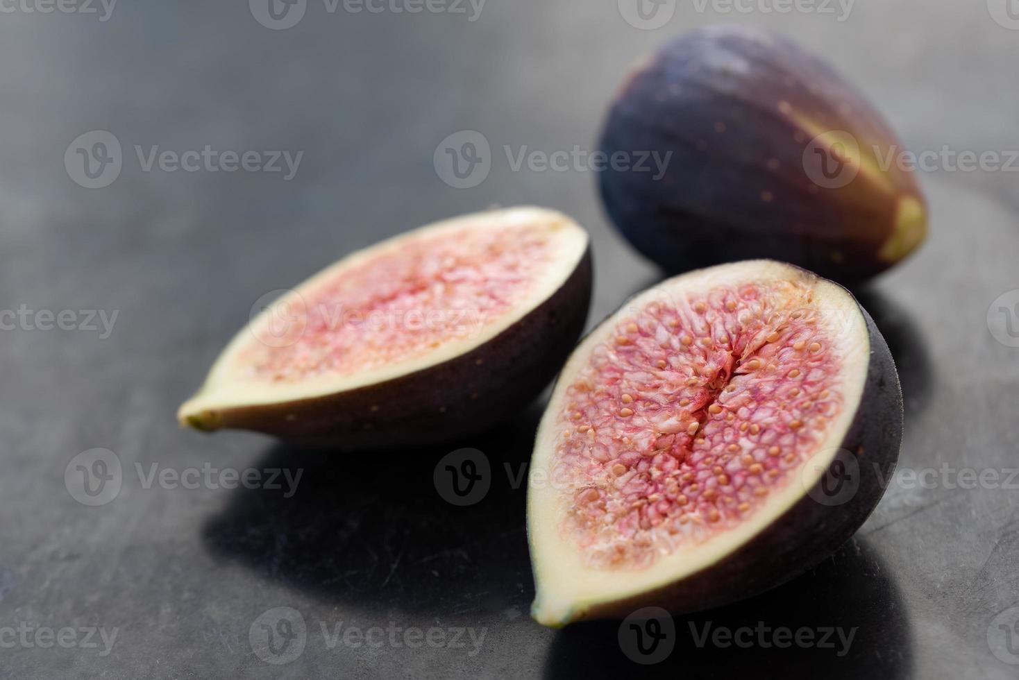 fresh figs lie next to each other, against a gray background photo
