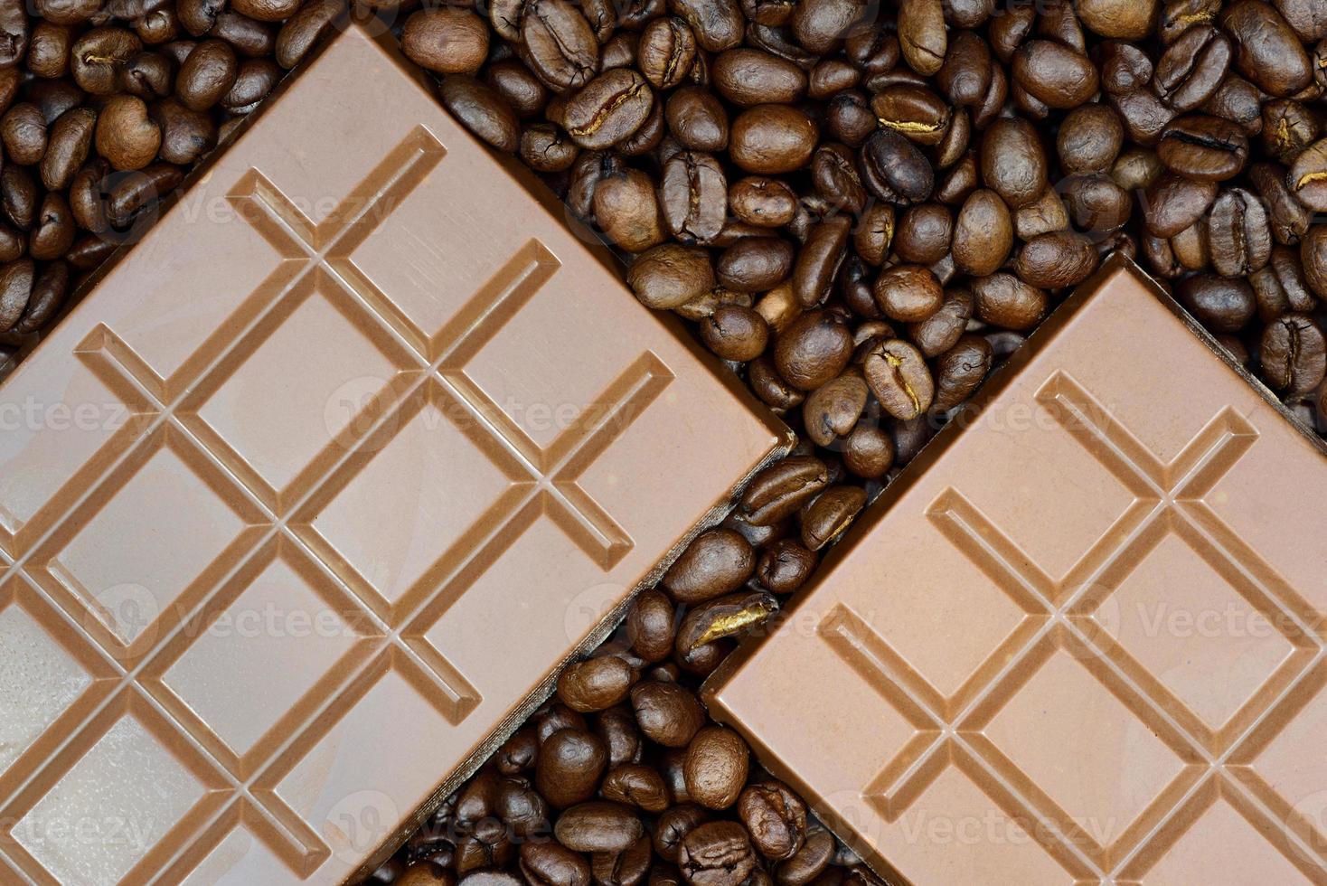 Background and texture of two bars of chocolate lying on brown coffee beans photo