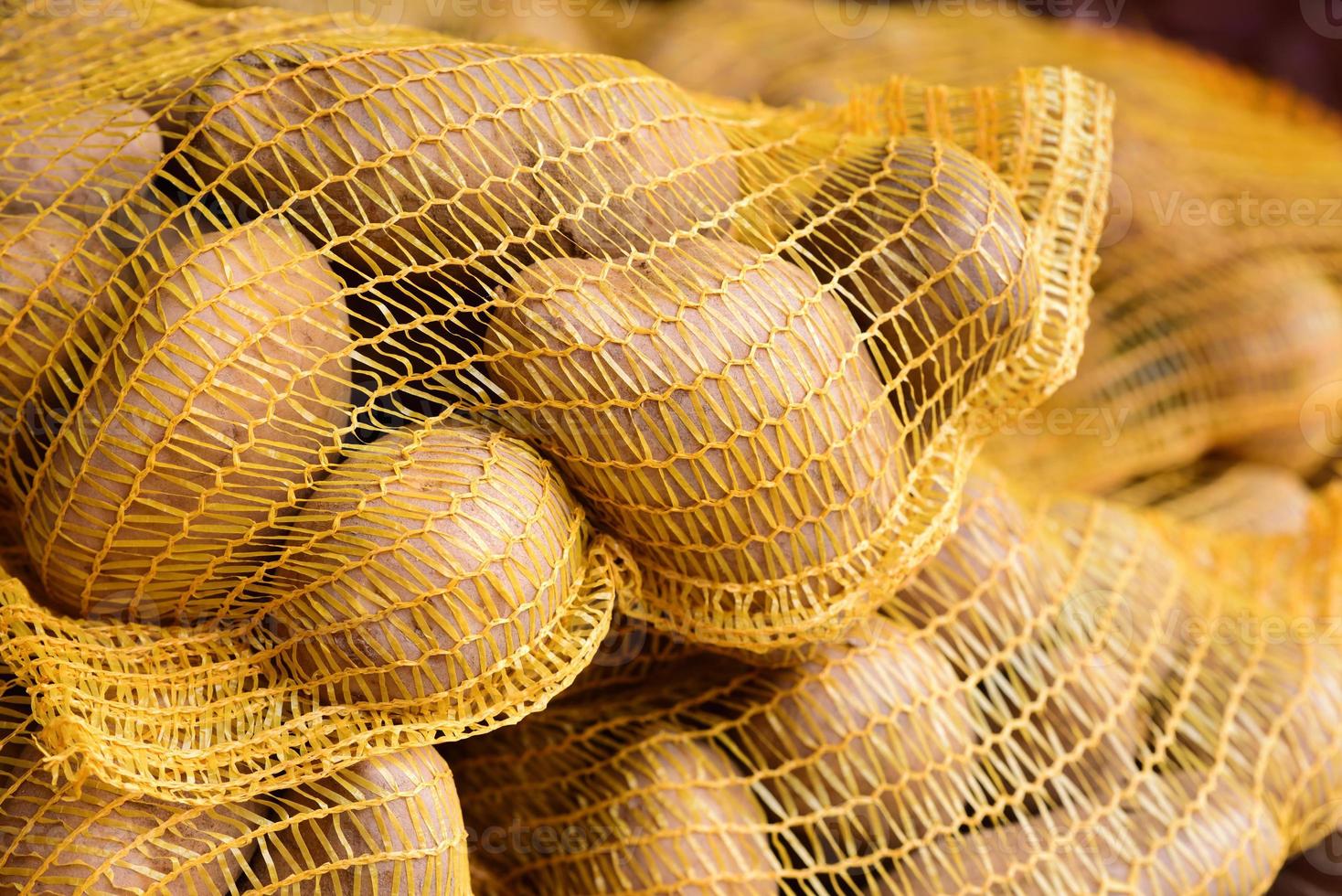 Freshly harvested potatoes in the net are for sale in the market photo