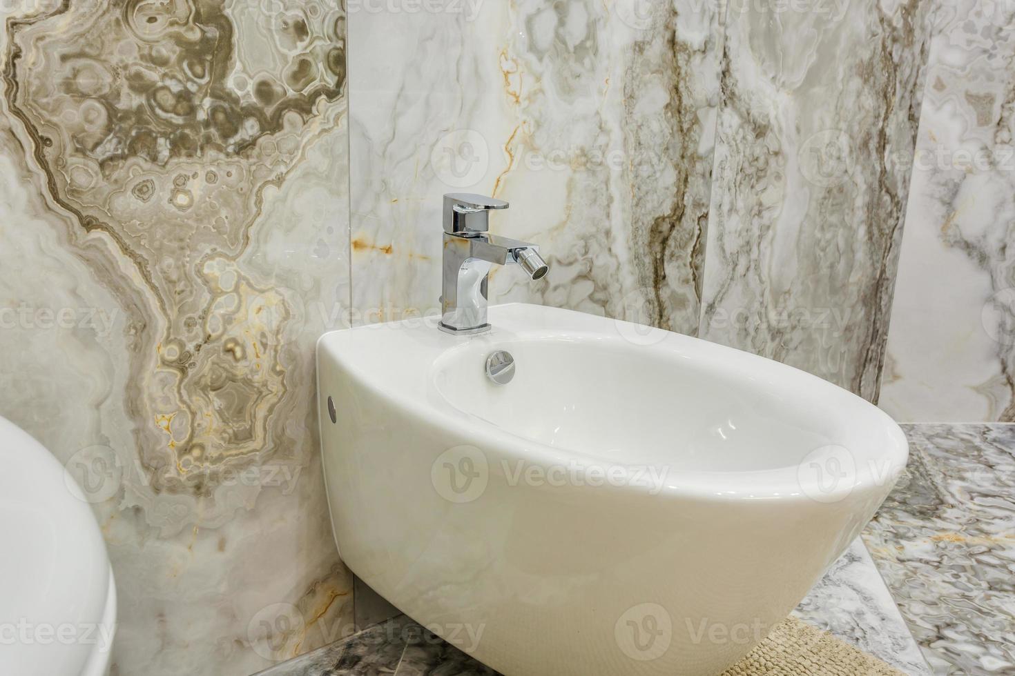 toilet and detail of a corner shower bidet with wall mount shower attachment photo