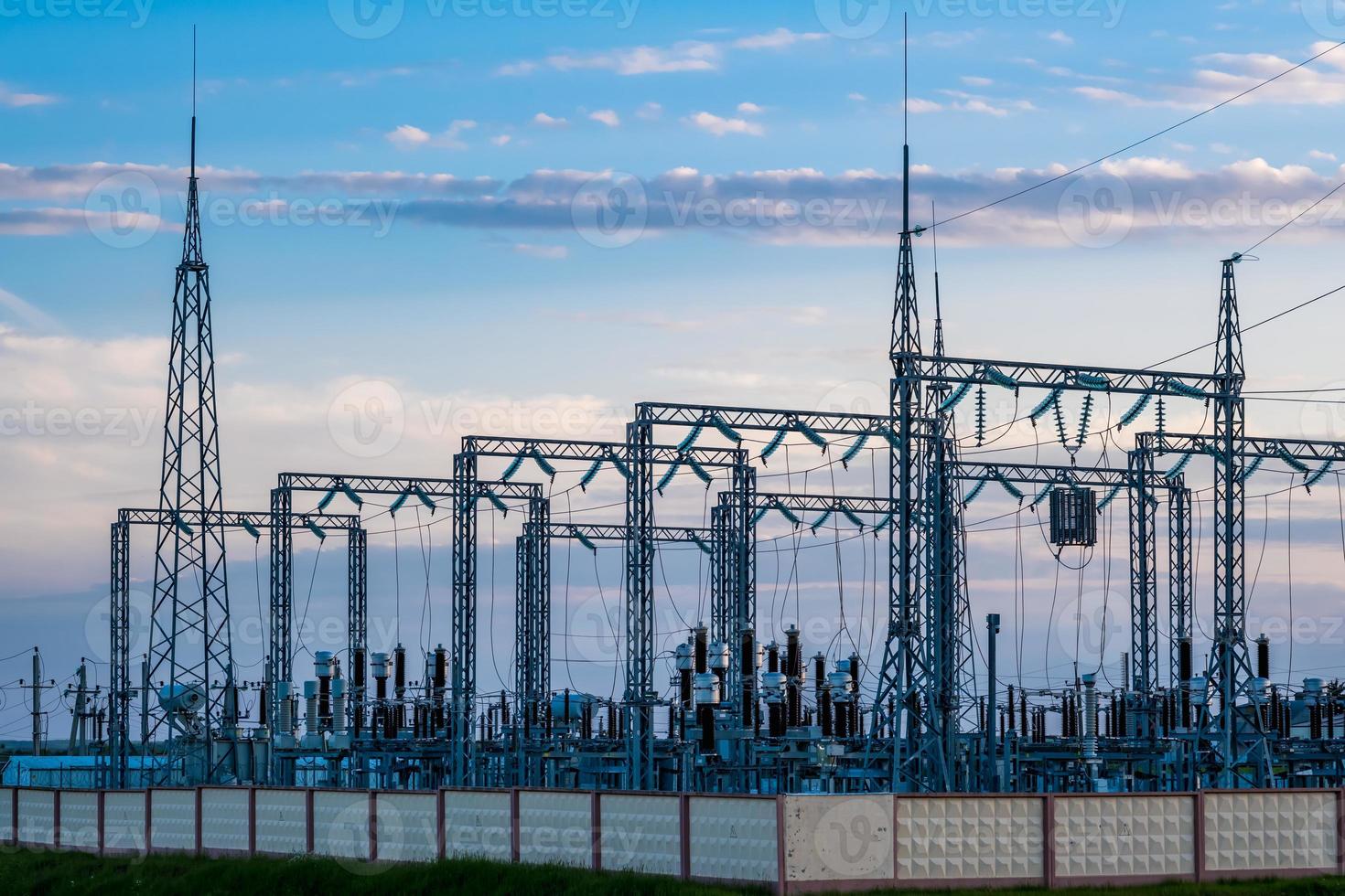 Silhouette of the high voltage electric pylon towers on the background of beautiful evening clouds photo