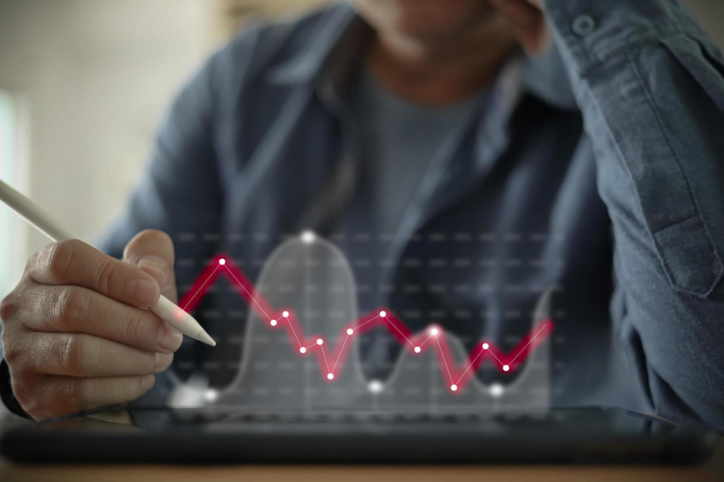 businessman working with statistics, looking at tablet screens with graphs and diagrams, checking financial report presentation, look of concern photo