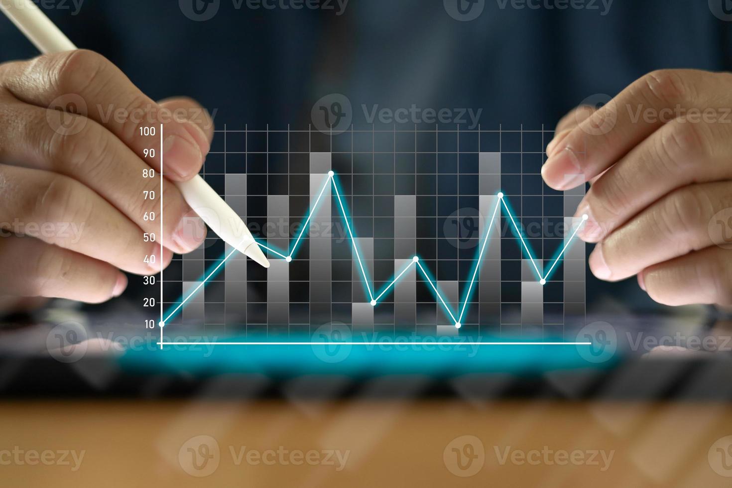 Businessman with a tablet on table And write on the screen That shows a business graph. The concept of starting a new business that goes better. Closeup of a man use pen with tablet. photo